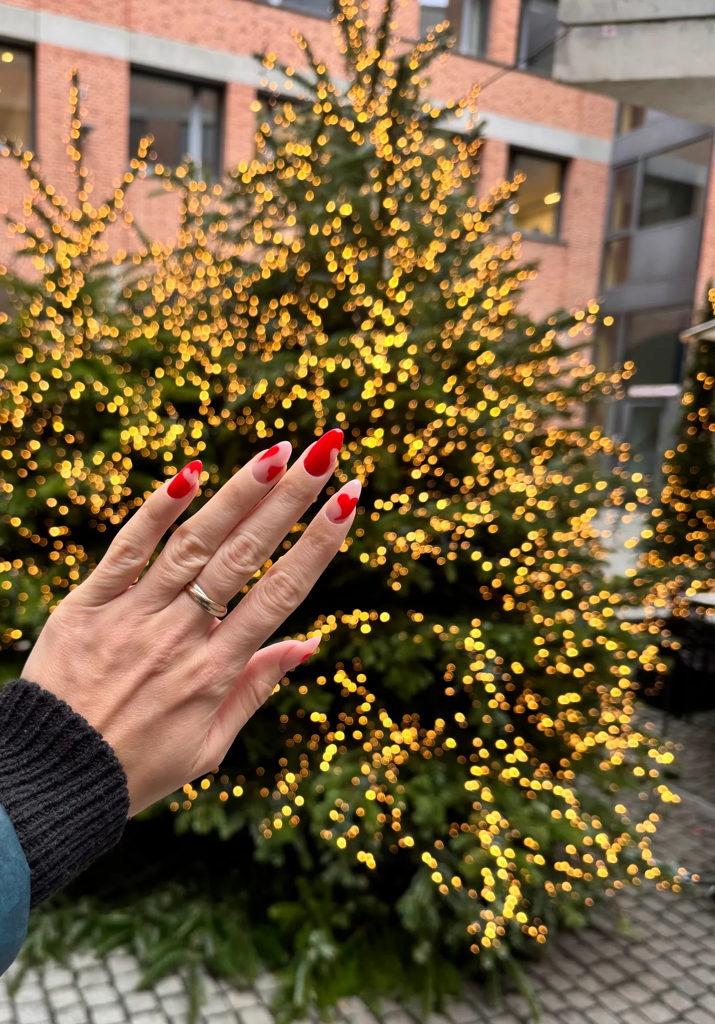Rote Nägel vor goldenen Lichterketten
